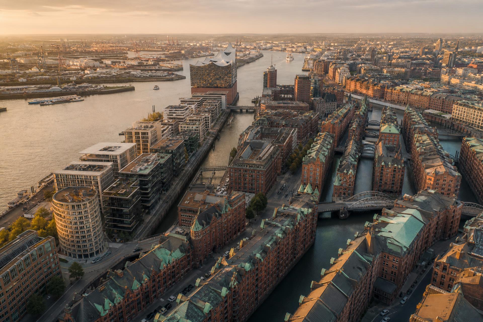 Aerial view of Hamburg at golden hour with the Elbphilharmonie on the Elbe, modern HafenCity buildings and the historic Speicherstadt warehouse district